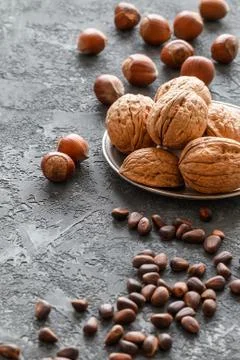 Different nuts on dark stone table. hazelnut, walnuts, cedar Stock Photos