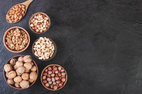 Different nuts in dishes, walnuts, hazelnuts, cashews and almonds Stock Photos