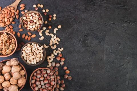 Different nuts in dishes, walnuts, hazelnuts, cashews and almonds Stock Photos