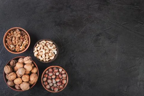 Different nuts in dishes, walnuts, hazelnuts, cashews and almonds Foto stock