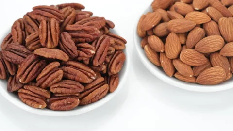 Different nuts pecans, almonds, hazelnuts on white background, rotation Stock Footage 153798396