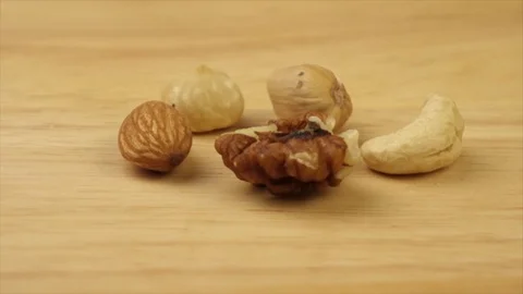 Different nuts rotate 360 degrees on a wooden platform 스톡 동영상 119284503