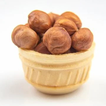 Different nuts in a waffle basket on a white background. Vitamin wholesome fo Stock Photos