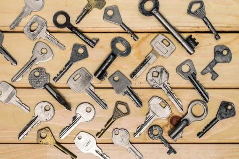 Different old keys, top view on a wooden table Stock Photos