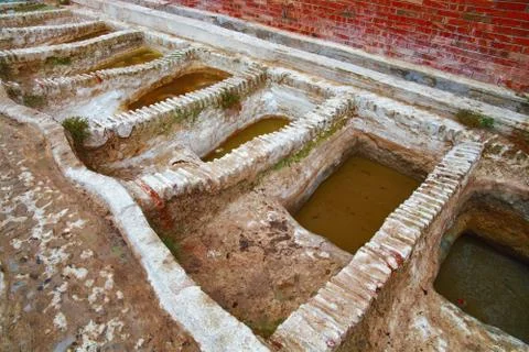 Different old stone vats with dye for leather at Tannery of Tetouan Medina. Stock Photos