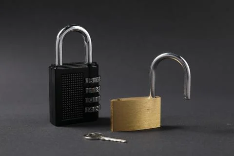 Different padlocks and key on black background, closeup Stock Photos