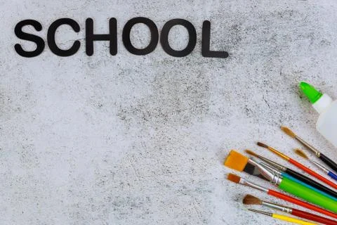 Different paint brushes on a white background with text school. Stock Photos