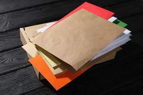 Different paper envelopes and parcel on black wooden table, closeup. Post o.. Foto stock
