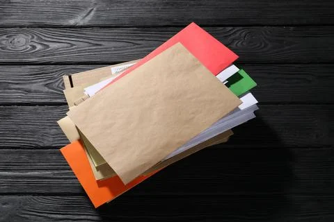 Different paper envelopes and parcel on black wooden table. Post office Foto stock
