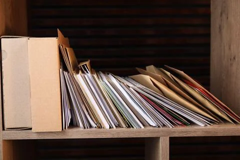 Different paper envelopes and parcels on wooden shelf in post office Stock Photos