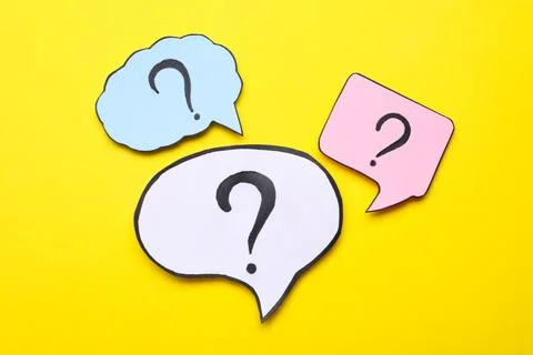 Different paper speech bubbles with question marks on yellow background, fl.. Foto stock