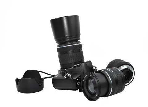 Different part of a black digital camera scattered across a white background Stock Photos