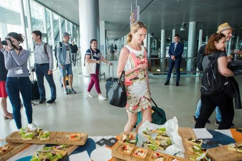 Different passengers try snacks and drinks from free degustation table in Lviv 写真素材
