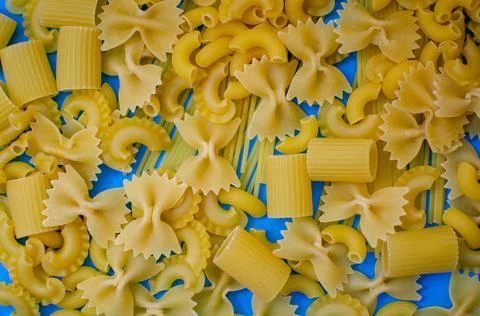 Different pasta on a blue background. Stock Photos