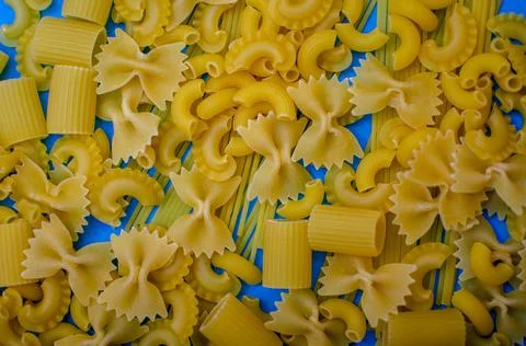 Different pasta on a blue background. Stock Photos