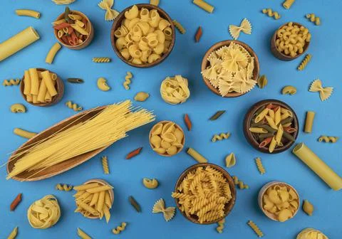 Different pasta types on blue background, top view Stock Photos
