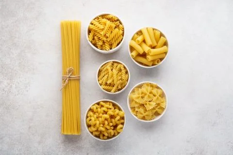 Different pasta varieties on light gray background. Stock Photos