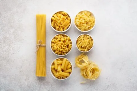 Different pasta varieties on light gray background. Stock Photos