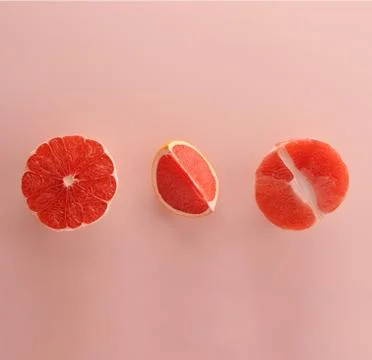 Different pieces of Grapefruit  on the pink background. Stock Photos