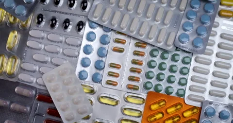 Different pill foils used in the pharmaceutical industry spinning background Stock Footage 251728848