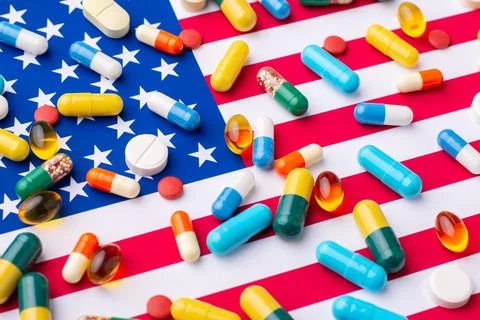 Different pills and tablets on flag of US Stock Photos