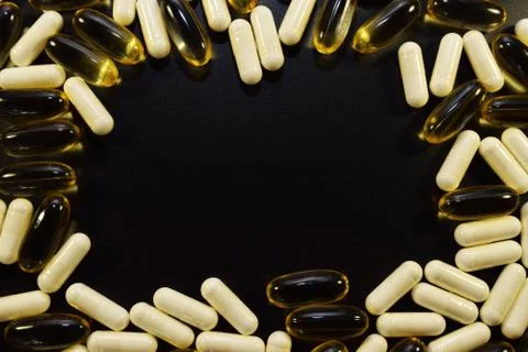 Different pills on a black background. Stock Photos