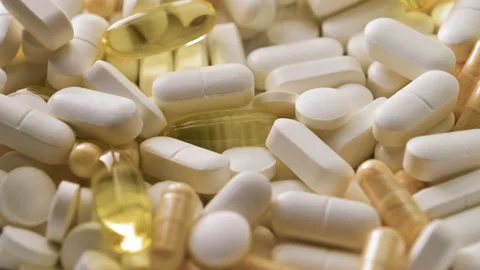 Different pills with capsules and tablets falling on white table, concept of Stock Footage 153023618