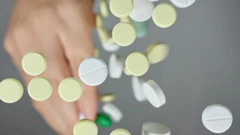 Different pills fall from human palm onto a flat transparent surface like drugs, Stock Footage 261185656