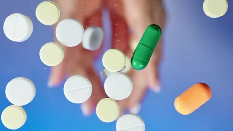 Different pills fall from human palms onto a flat transparent surface like Stock Footage 261185609