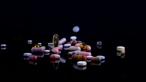 Different pills falling on black background Stock Footage 170621244