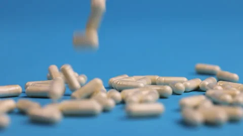 Different pills falling on blue background Stock Footage 276507987
