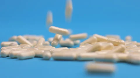 Different pills falling on blue background Stock Footage 276511733