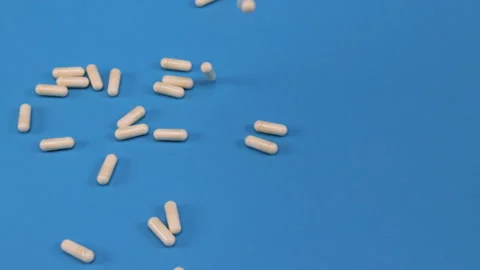 Different pills falling on blue background Stock Footage 276521786