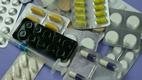Different pills spinning on blue background Stock Footage 128043468