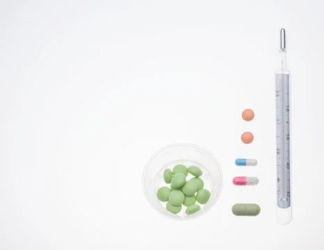 Different pills with thermometer on white background Stock Photos