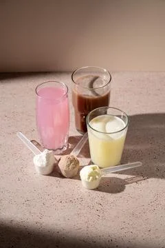 Different protein shake drinks in glasses and protein powder in scoops Stock-Fotos