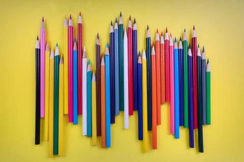 Different random art coloring pencils on a bright yellow background Stock Photos