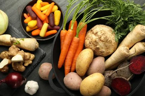 Different raw root vegetables on black table, flat lay Stock Photos
