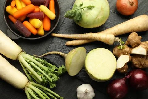 Different raw root vegetables on black table, flat lay Stock Photos