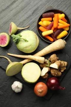 Different raw root vegetables on black table, flat lay Stock Photos