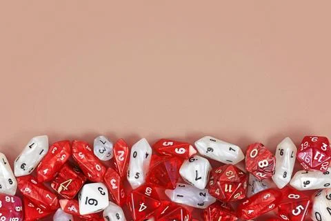 Different red roleplaying RPG dice at bottom of beige background with blank Foto stock