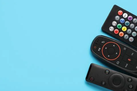 Different remote controllers on blue background 库存照片