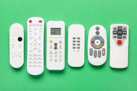 Different remote controllers on green background 库存照片