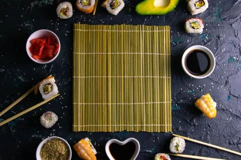 Different roles, avocado, red marinated ginger, rice, soy sauce are laid out  Stock Photos