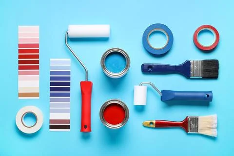 Different rollers with brushes, cans of paints, palette samples and adhesive  Stock Photos