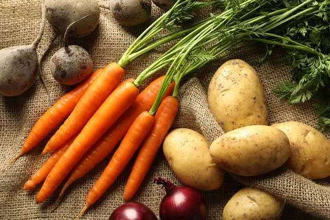 Different root vegetables on burlap fabric, flat lay Stock Photos