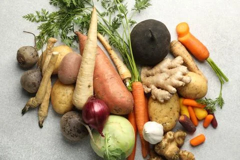 Different root vegetables on light grey table, flat lay Stock Photos