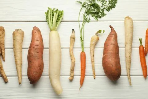 Different root vegetables on white wooden table, flat lay Stock Photos