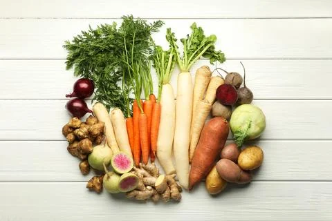 Different root vegetables on white wooden table, flat lay Stock Photos