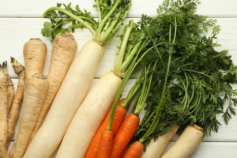 Different root vegetables on white wooden table, flat lay Stock Photos